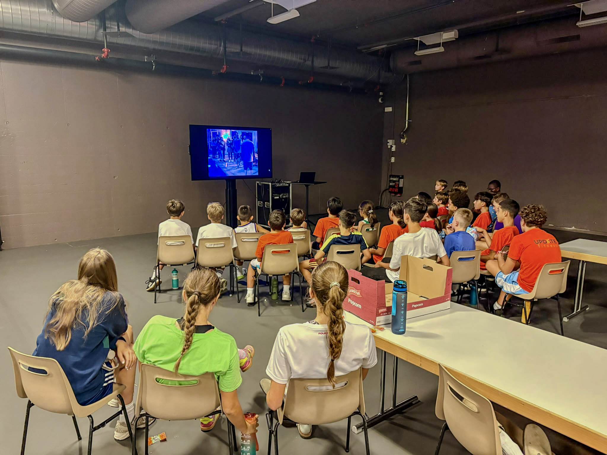 Camper schauen gemeinsam einen Film auf der Leinwand