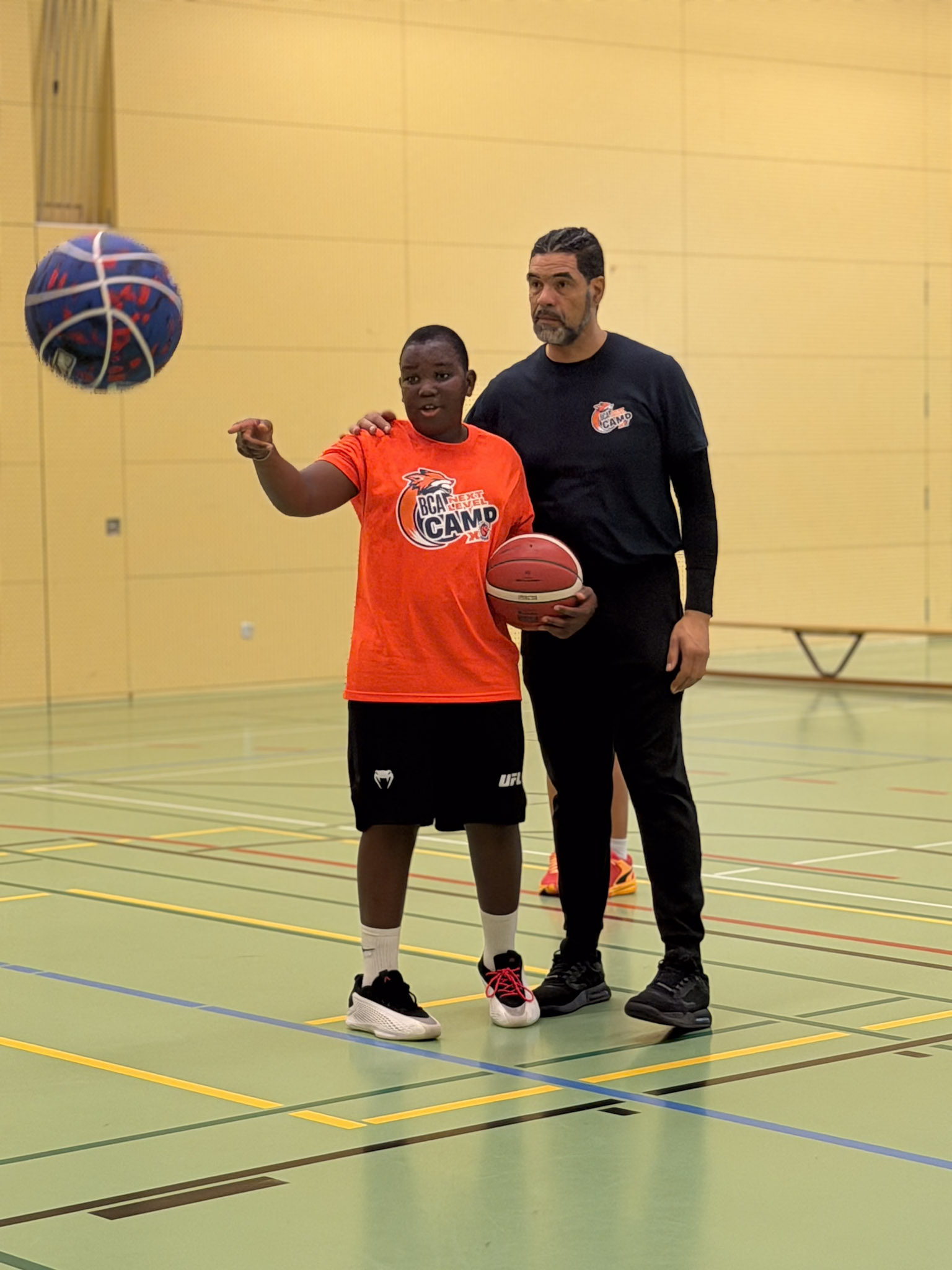Ein Trainer arbeitet mit einem Camper am Ballhandling